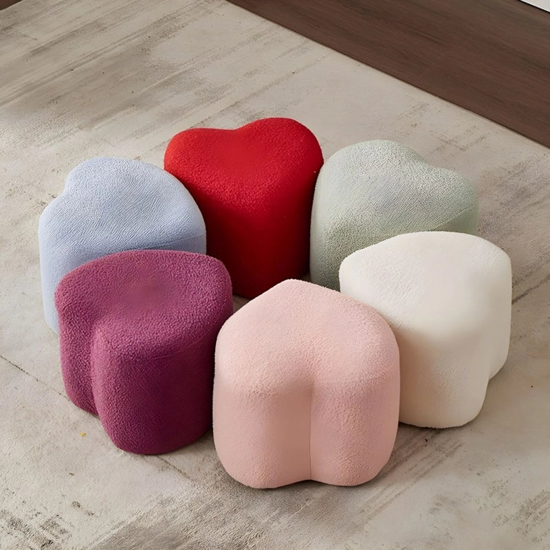 Its heart-shaped silhouette, upholstered in soft fleece-like fabric, delivers both visual appeal and gentle comfort.