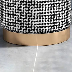 Round stool with houndstooth pattern top and gold base on a light gray floor.